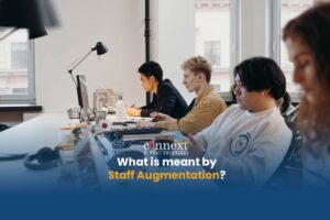 What is meant by Staff Augmentation four people using laptops corporate office remote staff augmentation