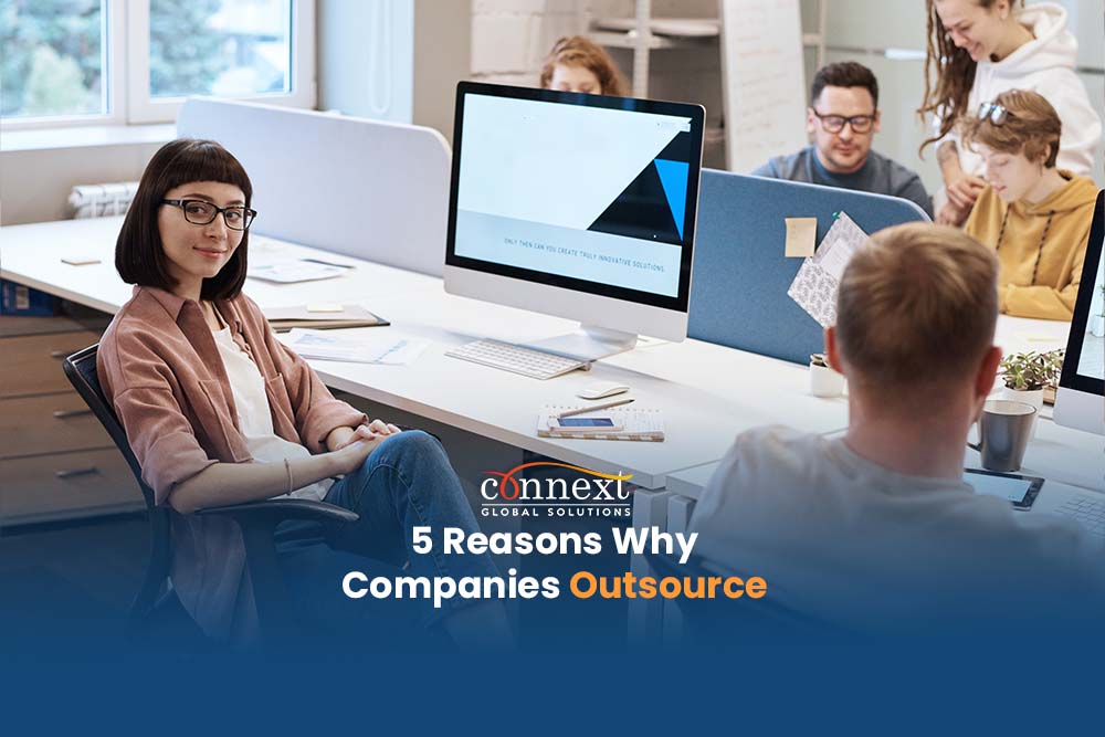 5-Reasons-Why-Companies-Outsource-woman-in-office-desk-space-with-co-workers