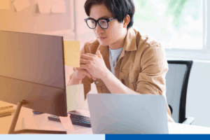 Bookkeeper in the Philippines working at a computer in a modern office, reviewing financial data for an offshore client.