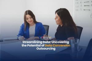 Streamlining-data-uncovering-the-potential-of-data-conversion-outsourcing-two-woman-sitting-at-desk-with-laptops-in-office