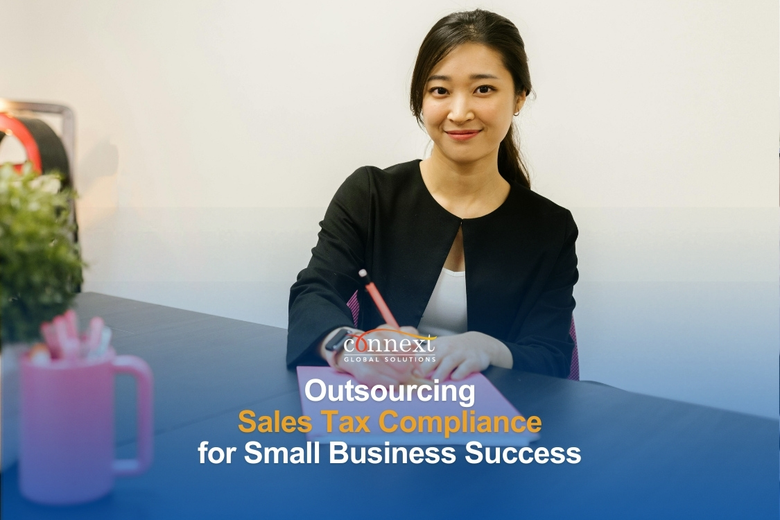 outsourcing-Sales-Tax-Compliance-for-Small-Business-Success-a-smiling-asian-woman-in-corporate-attire-behind-a-desk-in-office