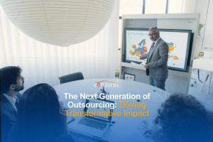 The Next Generation of Outsourcing: Driving Transformative Impact man presenting in a conference room meeting full of people