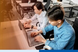 asian freelancers and independent contractors in corporate attire working on a laptop in an office