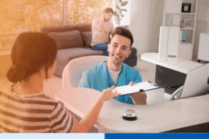 Front desk healthcare worker assisting patient with paperwork — highlights communication and workflow considerations in overcoming challenges in RCM offshoring.