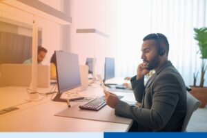 man in porfessional attire wearing a headset presenting using desktop in office