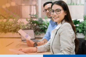 Two young professionals smiling while working.