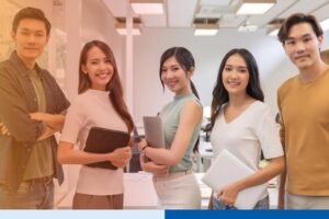 smiling asian people in corporate attire holding tablets