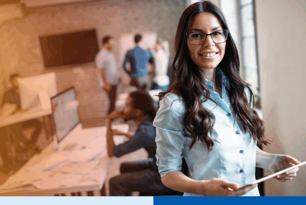 woman with glasses in professional corporate attire smiling with office background