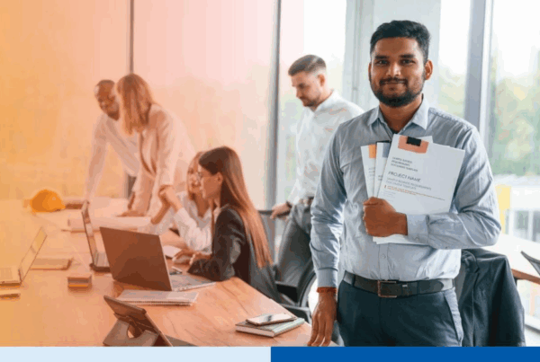 man holding project folders wearing corporate attire smiling in office in office setting meeting