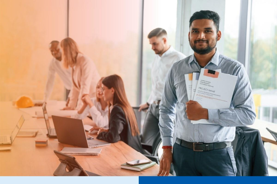 man holding project folders wearing corporate attire smiling in office in office setting meeting