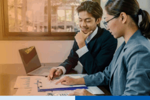 smiling people in corporate suit attire with paperwork and laptop in office