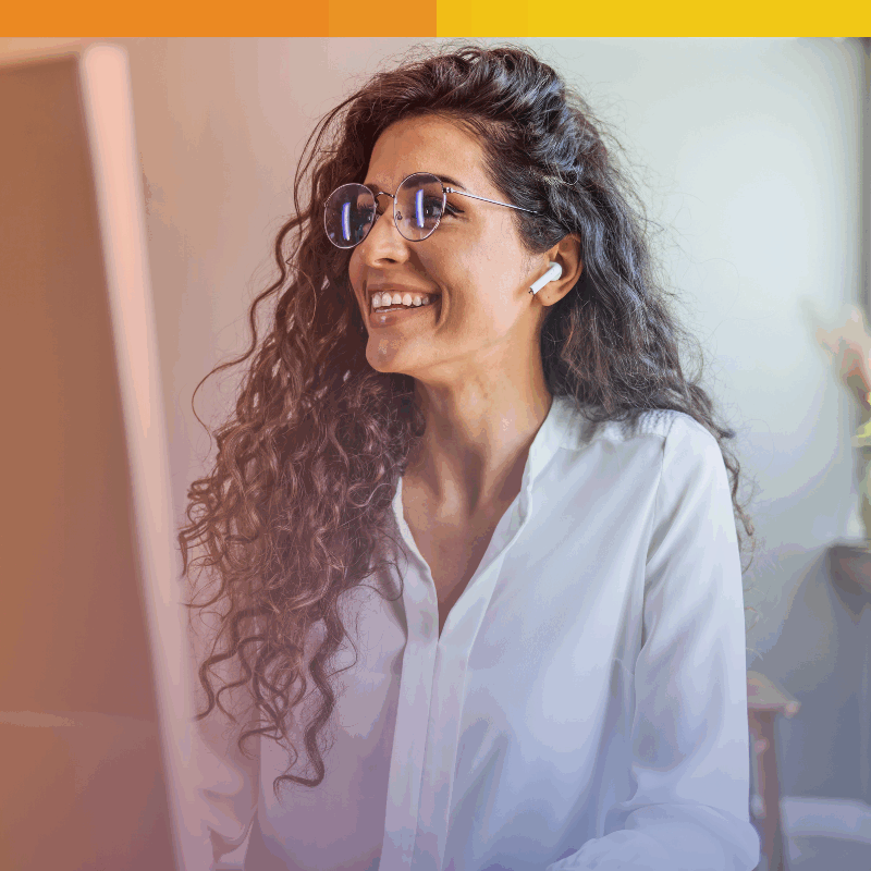 Smiling professional reviewing content online—illustrating the people behind content moderation outsourcing in a trusted, remote work environment.