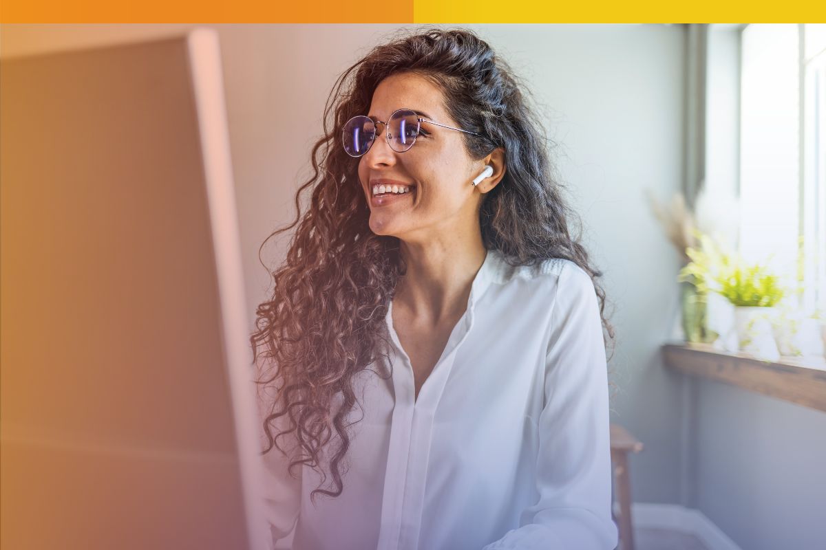 Smiling professional reviewing content online—illustrating the people behind content moderation outsourcing in a trusted, remote work environment.