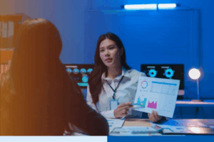 Asian businesswoman showing charts to colleague in office
