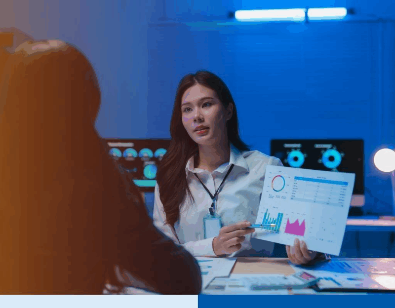 Asian businesswoman showing charts to colleague in office