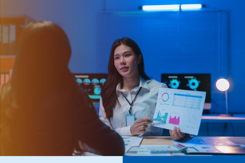 Asian businesswoman showing charts to colleague in office