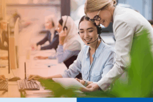 selective focus of smiling multicultural businesswomen using tablet together at workplace in office