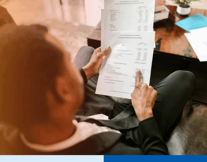 Business professional reviewing financial documents and expenses related to cross border outsourcing for Canadian SMEs, highlighting cost management and financial analysis