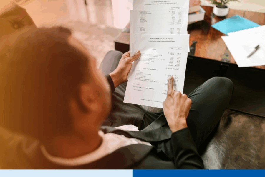 Business professional reviewing financial documents and expenses related to cross border outsourcing for Canadian SMEs, highlighting cost management and financial analysis