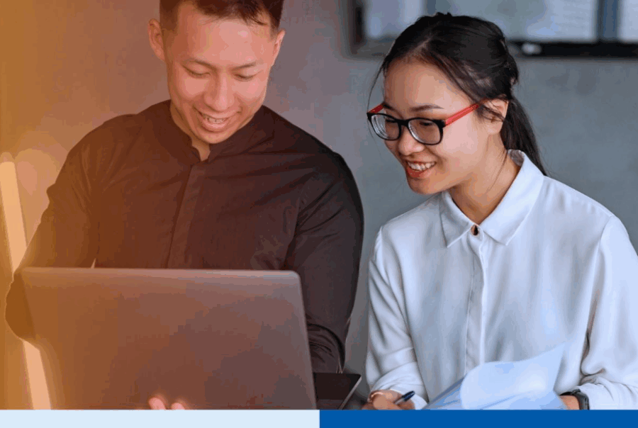 Two professionals collaborate on payroll outsourcing tasks using a laptop and documents in a modern office setting, illustrating teamwork and efficiency in the Philippines payroll outsourcing industry for U.S. firms in 2026.