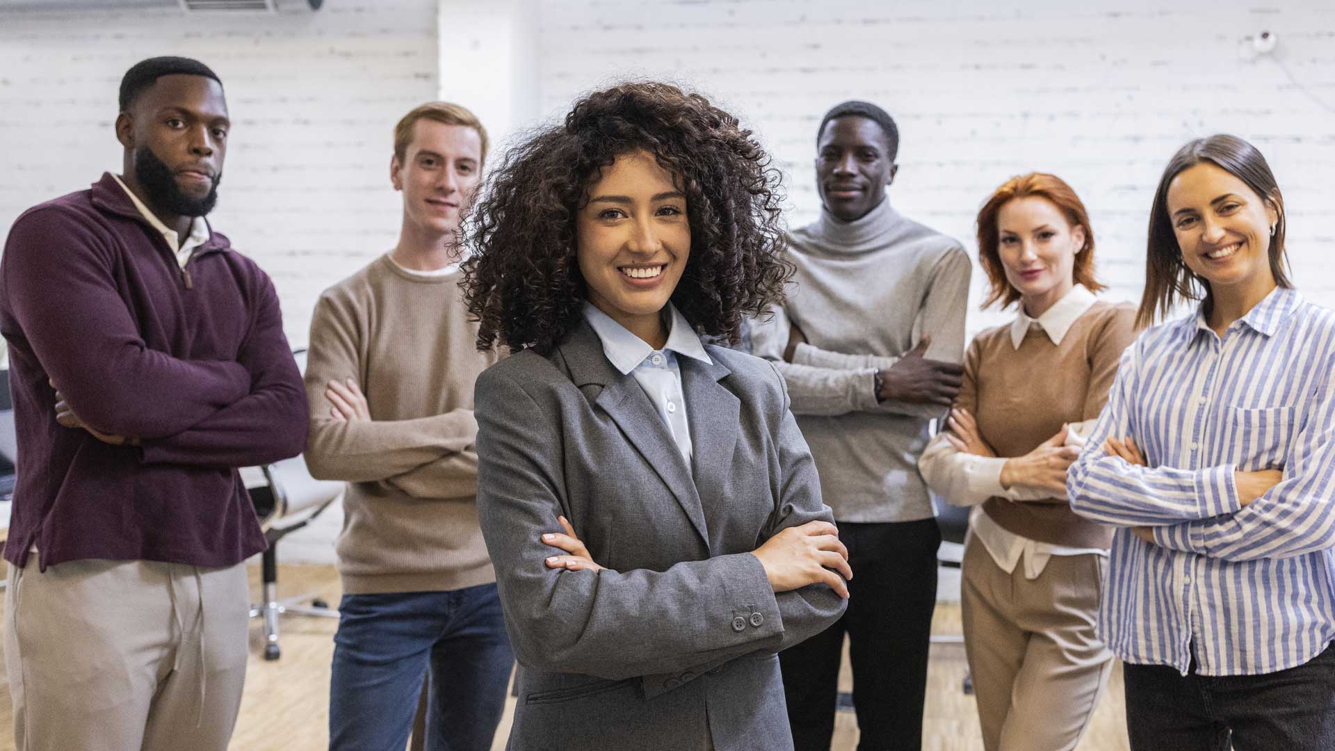 High performing business team smiling with confidence in modern office