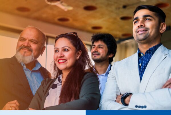 Corporate professionals standing with folded arms, smiling confidently in an office