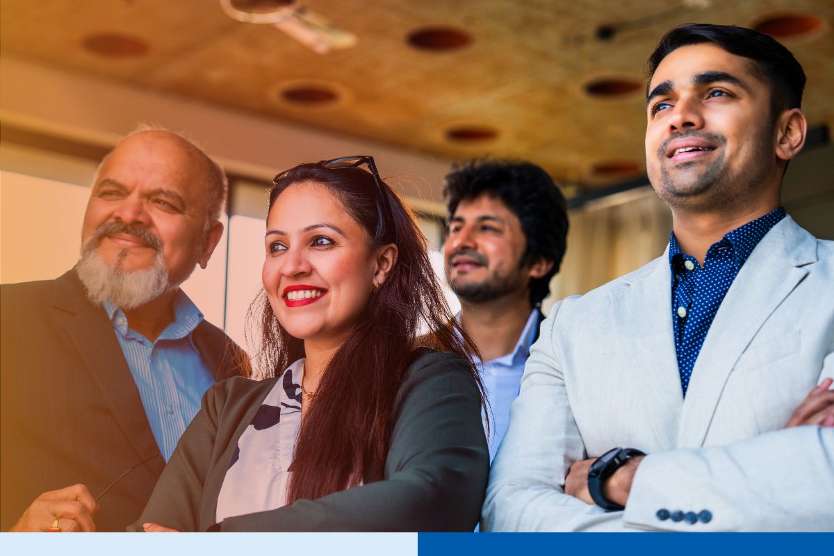 Corporate professionals standing with folded arms, smiling confidently in an office
