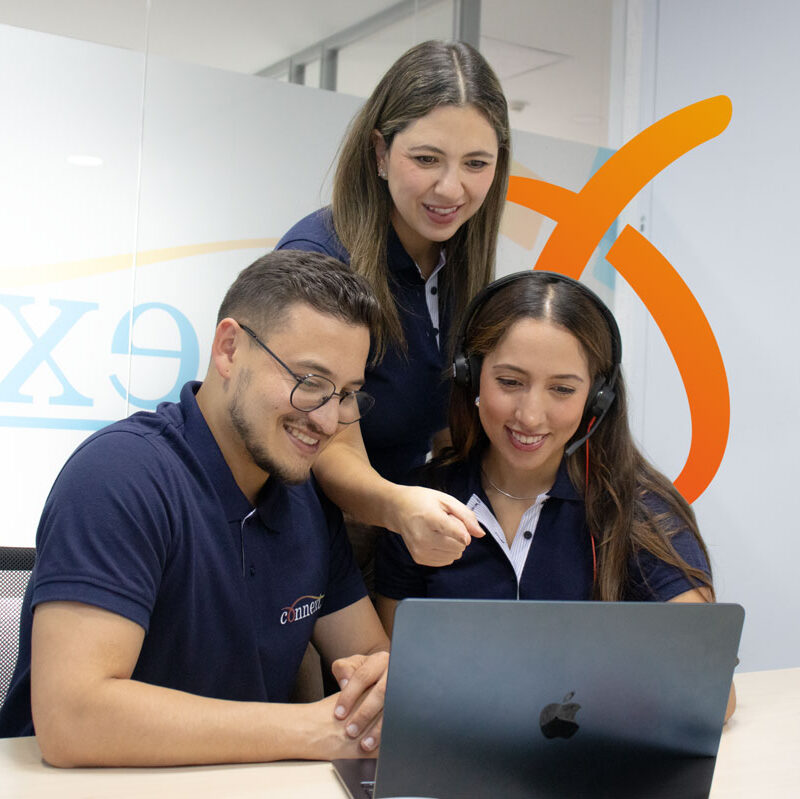 Connext Colombia team collaborating at a laptop.