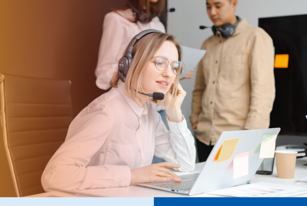 Outsourced customer support agent trained on brand voice taking calls with a headset at her laptop