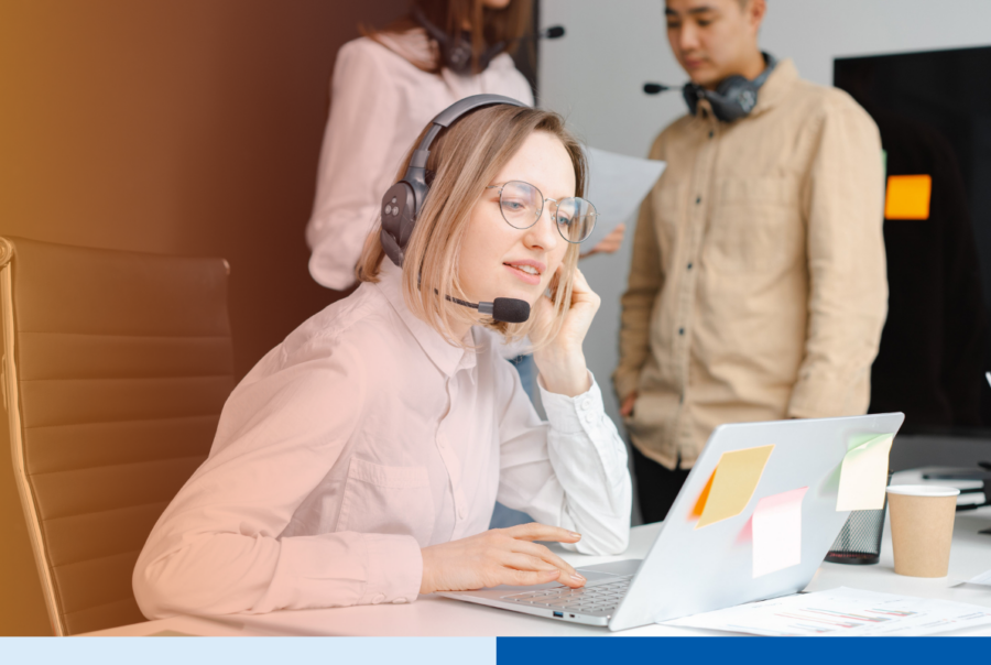 Outsourced customer support agent trained on brand voice taking calls with a headset at her laptop