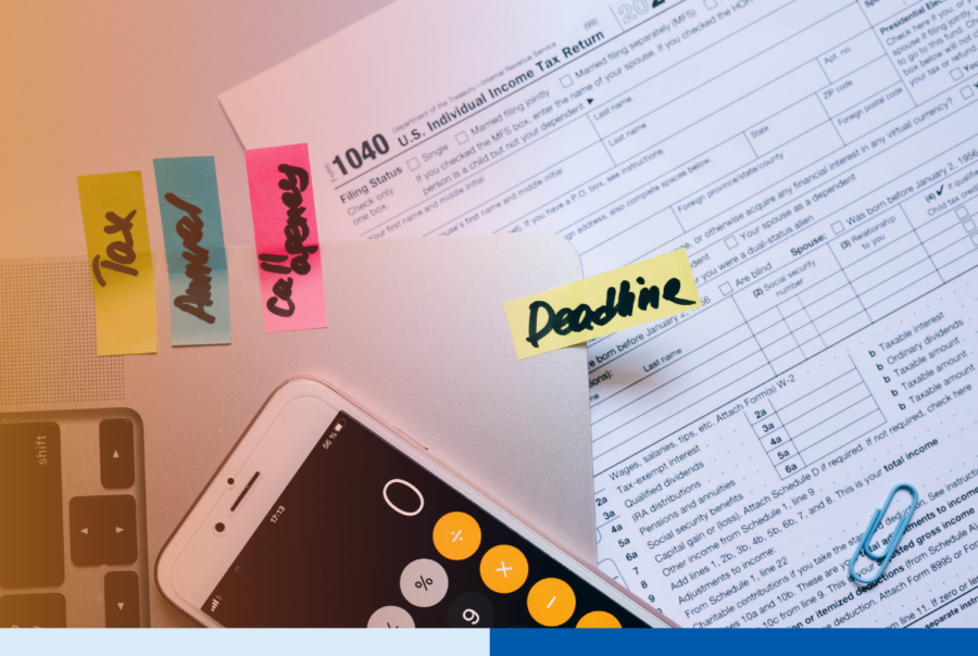 Tax documents, calculator, smartphone, and financial reports on a desk during tax season planning