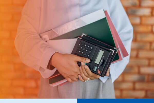 Accountant with calculator reviewing financial records, representing nearshore accounting team Mexico supporting US back-office finance operations