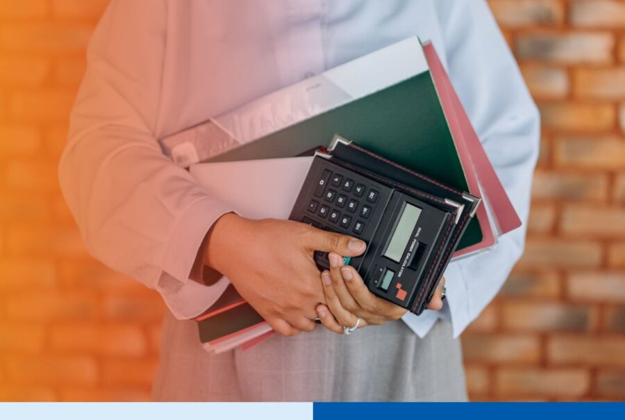 Accountant with calculator reviewing financial records, representing nearshore accounting team Mexico supporting US back-office finance operations