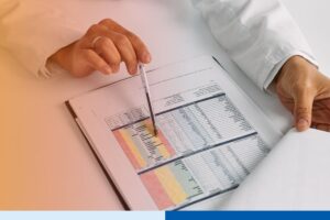 A healthcare professional or analyst reviews a detailed, color-coded medical chart on a clipboard, highlighting outsourced healthcare back-office solutions and operational efficiency.