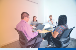 Business leaders reviewing Colombia nearshore staffing plans together at a laptop-equipped table in a modern office
