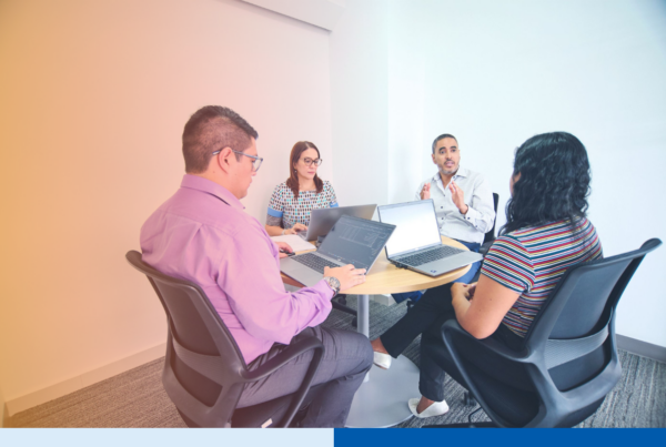 Business leaders reviewing Colombia nearshore staffing plans together at a laptop-equipped table in a modern office
