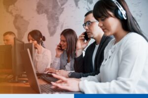 Offshore team members at computer workstations, some on phone calls, during a large-scale offshore team ramp