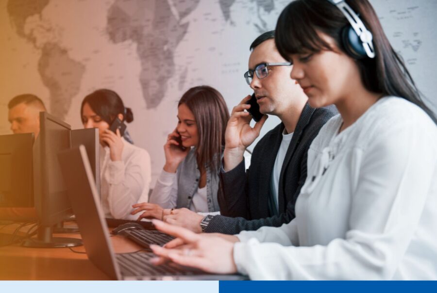 Offshore team members at computer workstations, some on phone calls, during a large-scale offshore team ramp
