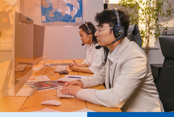 Nearshore support team wearing headsets and working at desks in a modern office