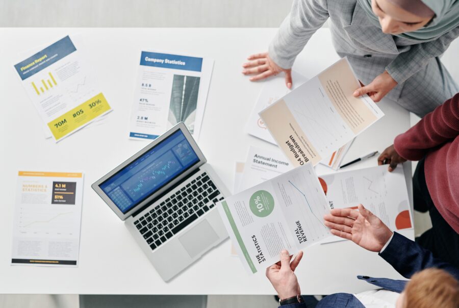 diverse finance team reviewing reports on laptop
